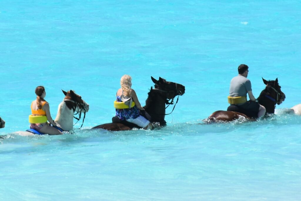 People Horseback Riding on Grand Cayman in the water.